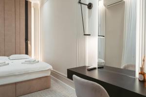 奥拉迪亚阿斯托瑞上豪大酒店的一间卧室配有书桌、一张床和镜子
