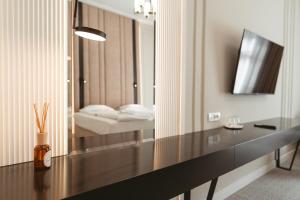 奥拉迪亚阿斯托瑞上豪大酒店的一间带镜子的卧室和一张带床的书桌