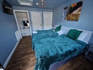 Longhope农场男孩宾馆的一间卧室配有一张带绿色床单的大床
