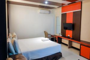 HiliotaluwaSummarend Hotel RedPartner的一间酒店客房,配有一张床和一台电视