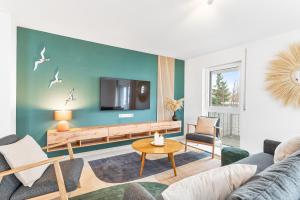 莱因费尔登-埃希特尔丁根Design-Apartment - Küche - Parken - zentral的客厅配有沙发和墙上的电视
