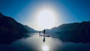 富士河口湖光风阁酒店的两个人站在水中的桨板上