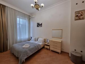 巴库Malakan apartment的一间卧室配有一张床、梳妆台和电视。