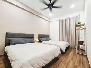 怡保The Cove Hillside Residence Ipoh的配有吊扇的客房内的两张床