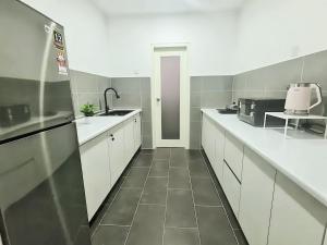 怡保The Cove Hillside Residence Ipoh的一间大厨房,配有白色的橱柜和水槽