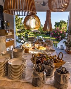 塞奥洛戈斯LOGOS Beach Village的桌上放有盘子和碗的食物