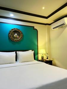 胡志明市La Serena Boutique Hotel的卧室配有白色的床和绿色的墙壁