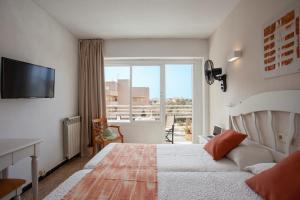 西洛特BJ Playamar Hotel & Apartamentos的酒店客房设有一张床和一个阳台。
