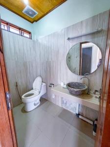 龙目岛库塔Lara Homestay的一间带卫生间、水槽和镜子的浴室