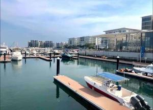 锡卜Beachfront 2BHK apartment at Al Mouj的停靠在码头的船坞