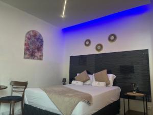 Matola40 40 Accommodation的一间卧室配有一张紫色照明的大床