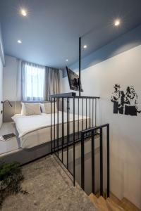 雅典Bonnie Athens by Nin&Bau的卧室配有一张床,墙上配有电视。