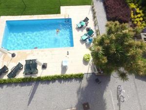 布拉加Casa Cachada的享有带椅子和棕榈树的游泳池的顶部景致