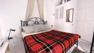 哈马马特Dar Essarouel Hammamet的一间卧室配有一张带红色和黑色毯子的床