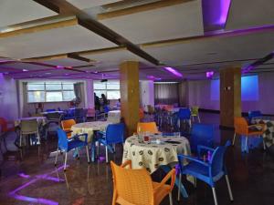 坎帕拉Royal Hotel Apartments的配有桌椅和紫色灯的房间