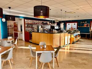 卡斯特拉纳格罗泰Hotel La Vetta Europa的一间带桌椅的餐厅和一间酒吧