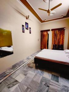 AyodhyaShantiniketan 4BHK Comfortable Family Stay in Ayodhya的一间卧室配有一张床和吊扇