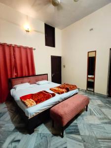 AyodhyaShantiniketan 4BHK Comfortable Family Stay in Ayodhya的一间卧室配有床和红色窗帘