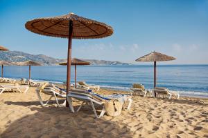 阿默达拉-伊拉克利翁TUI Magic Life Candia Maris - Adults Only的海滩上的一组椅子和遮阳伞