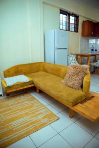 达累斯萨拉姆Travellers Home near Mlimani City Mall with free parking的一间厨房的房间里,一张棕色的沙发