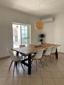 AroeiraNini's Beach House - Aroeira, Charneca da Caparica的用餐室内的一张木桌和椅子