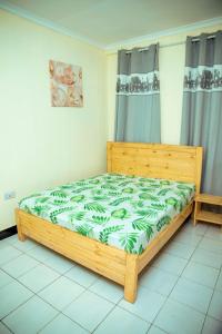 达累斯萨拉姆Travellers Home near Mlimani City Mall with free parking的一间卧室,卧室内配有一张木床