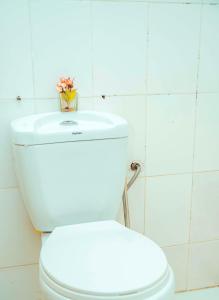 达累斯萨拉姆Travellers Home near Mlimani City Mall with free parking的白色的厕所,上面有花瓶