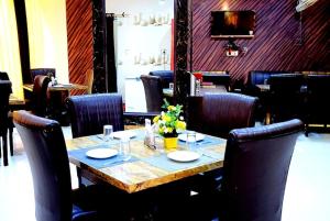 AyodhyaTaraji Resort Hotel & Restaurant Ayodhya的一间带木桌和椅子的用餐室