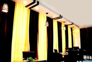 AyodhyaTaraji Resort Hotel & Restaurant Ayodhya的餐厅一排黄色和黑色窗帘