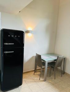 普拉托Piccolo appartamento a Prato的用餐室配有桌子和黑冰箱