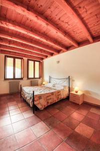 沃尔塔曼托瓦纳Agriturismo Case in Collina的一间带一张床的卧室,位于带木制天花板的房间内