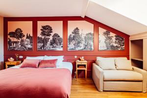 里昂Hôtel Maison Lacassagne Lyon的卧室设有红色的墙壁、一张床和一张沙发