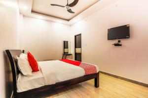 ChinhatVaibhav Laxmi Paradise的一间卧室配有一张床和一台平面电视