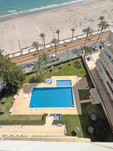 坎佩略Oasis Frente al Mar. Parking Gratis的享有游泳池和海滩的上方景色