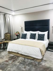 恩多拉MUKUBA HOTEL的一间卧室配有一张大床和蓝色床头板