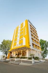 兰奇Bloom Hotel - Ranchi的街道上一座黄色和白色的大酒店建筑