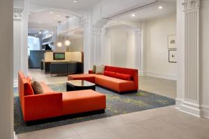 新奥尔良新奥尔良法国区/伊贝维尔万怡酒店的客厅配有2张橙色沙发和1张桌子