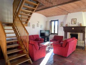 沃尔塔曼托瓦纳Agriturismo Case in Collina的一间带红色椅子和楼梯的客厅