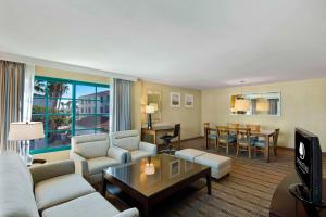 圣佩德罗圣佩德罗希尔顿逸林酒店的客厅配有沙发和桌子