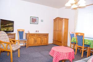 诺德奈Haus Ufen - In den Dünen 18c的客厅配有椅子、书桌和电视