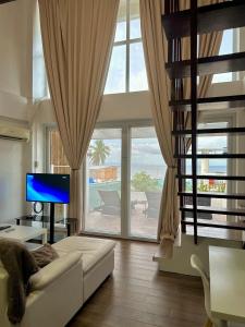 波尔多·格尼拉Arkipelago Beach Resort的客厅配有白色沙发和大窗户