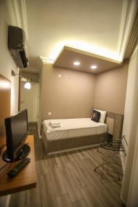 安塔利亚ÇEVİK PALACE HOTEL的一间卧室配有一张床和一台电视。