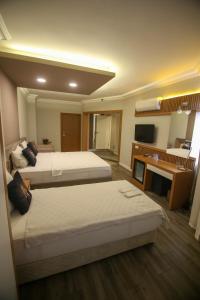 安塔利亚ÇEVİK PALACE HOTEL的酒店客房配有两张床和一张书桌