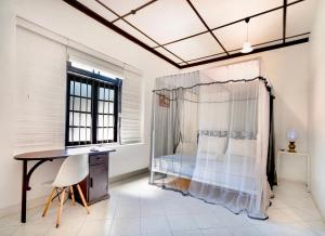 科伦坡Lost & Found - Colombo的一间卧室配有一张床、一张书桌和一个窗户。