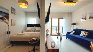 格但斯克Apartment MARINA Riverside Nadmotławie by TriApart的一间卧室配有一张床和一张蓝色的沙发
