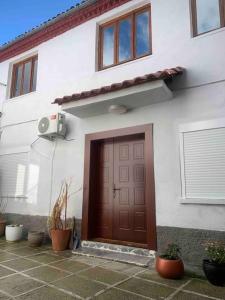 戈里察Traditional Bazaar Home2的一间白色的房子,有棕色的门和一些植物