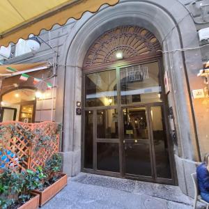 那不勒斯Napoli Centro Suite e Spa的玻璃门进入大楼的入口