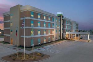 阿比林Home2 Suites By Hilton Abilene Southwest的前面有两面旗帜的大建筑