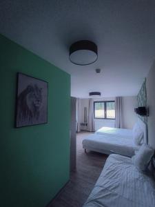 La Cluse et Mijoux约克斯城堡酒店的一间卧室设有两张床和绿色的墙壁