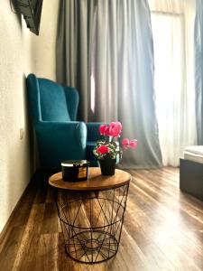 桑丹斯基Apartment Alex的客厅配有蓝色椅子和鲜花桌